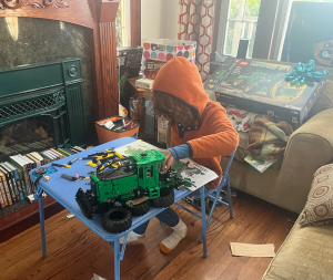 Nine year old boy assembling LEGO Technic John Deere 948L-II Skidder tractor set