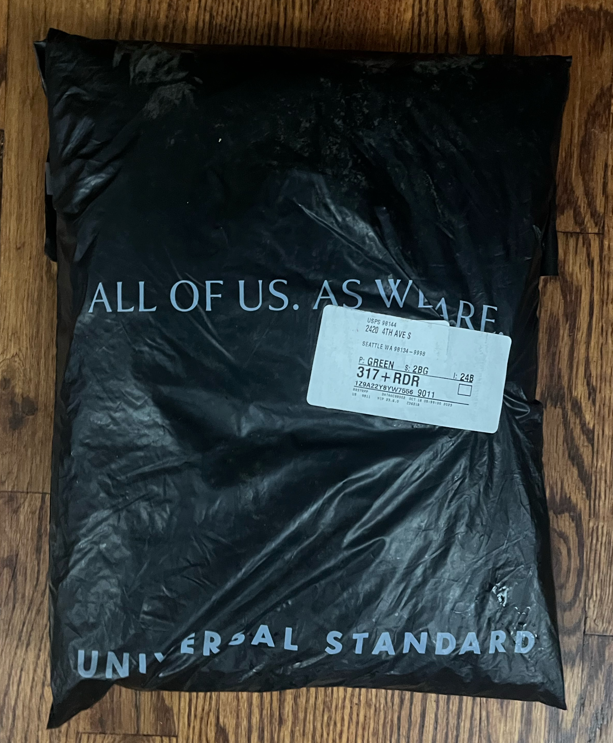 Universal Standard Mystery Box black bag packaging with three women's clothing items inside