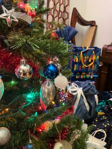 Close up of decorated Christmas Tree with holiday gift bags in background