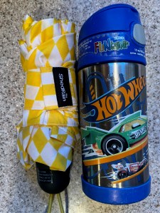 ShedRain Mini Manual compact umbrella folded next to kids