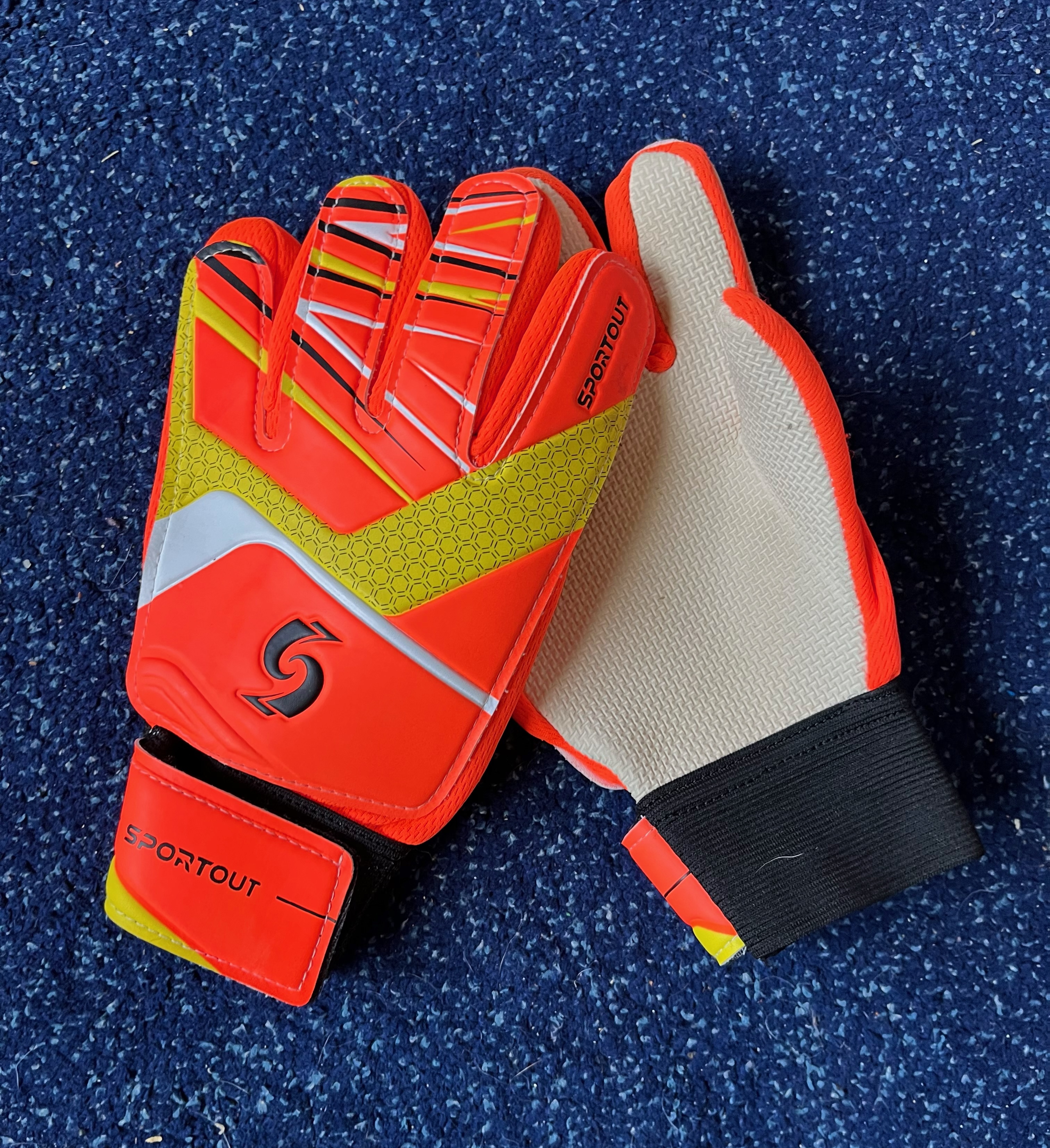 Sportout Kid goalie gloves with white non slip palm side showing on one glove against blue backgrouond