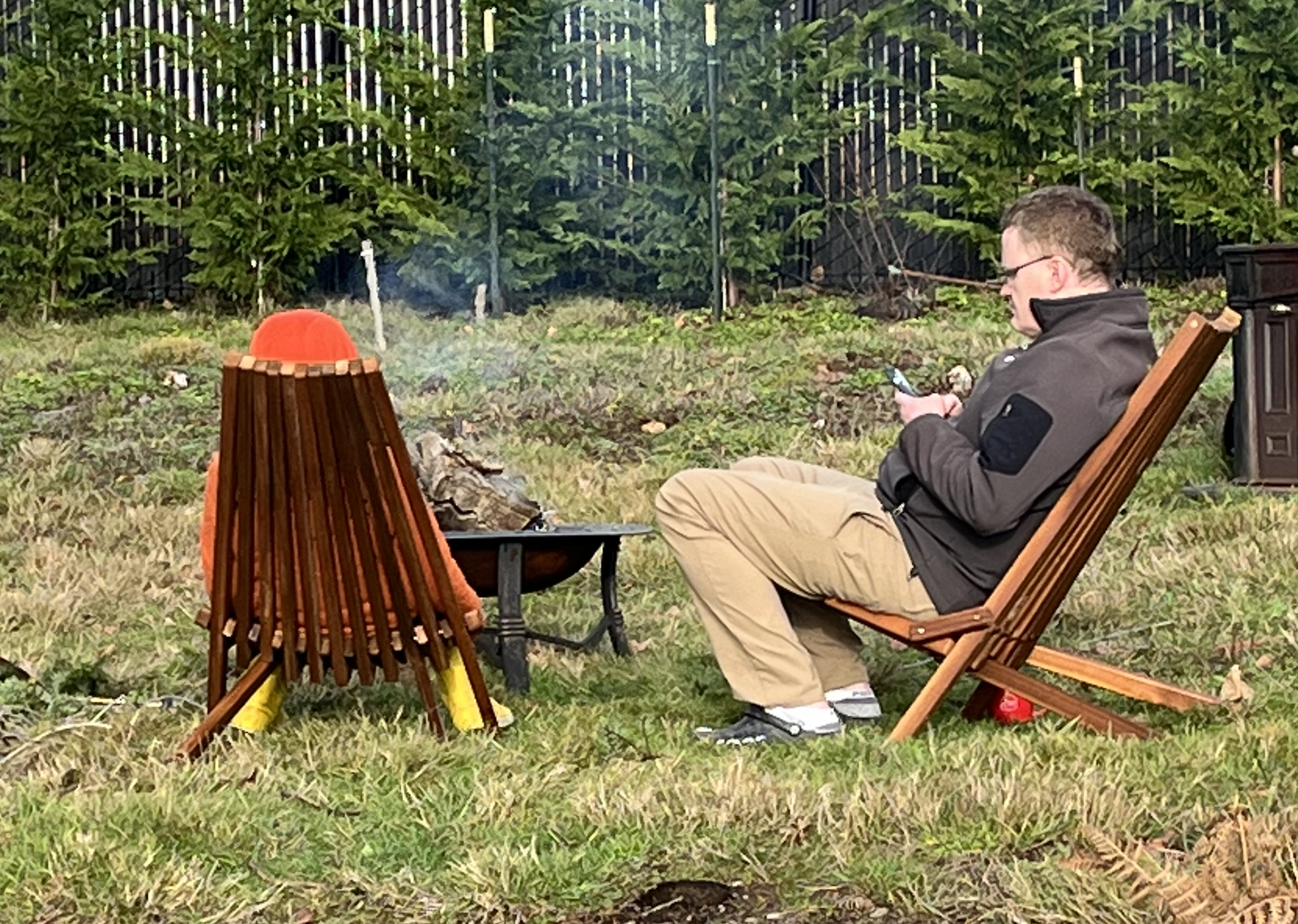 Tamarack folding wooden outdoor chairs around fire pit