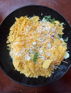 Tortilla chip crumbs from bottom of bag added to top of homemade southwest salad