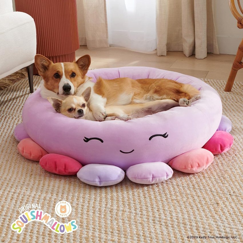 Choose from four different sizes to find the perfect fit for your pet. Squishmallows Beula the Octopus Pet Bed image from Amazon with two dogs curled up in pink pet bed