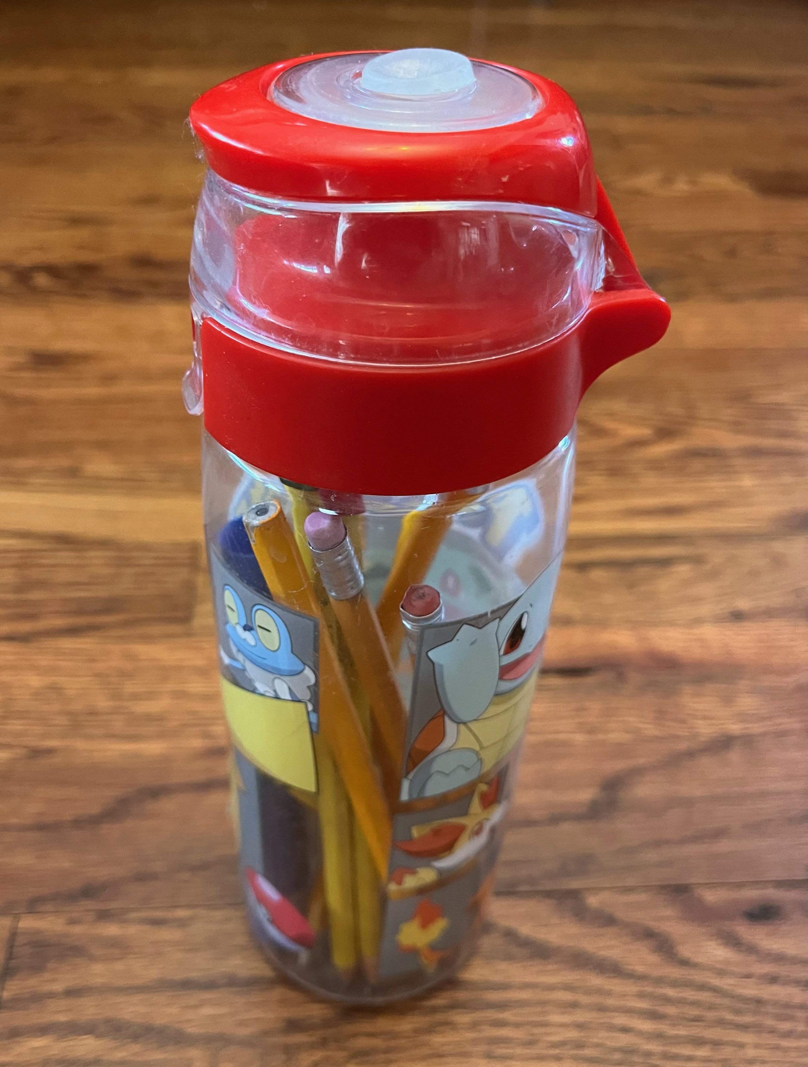 Pokemon water bottle with pencils, markers, and pens stored inside